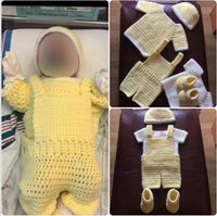 New born baby boy wearing a complete handmade crochet set which includes baby booties, overalls, a yellow top, a white top, and a matching hat from kimbertskreations.