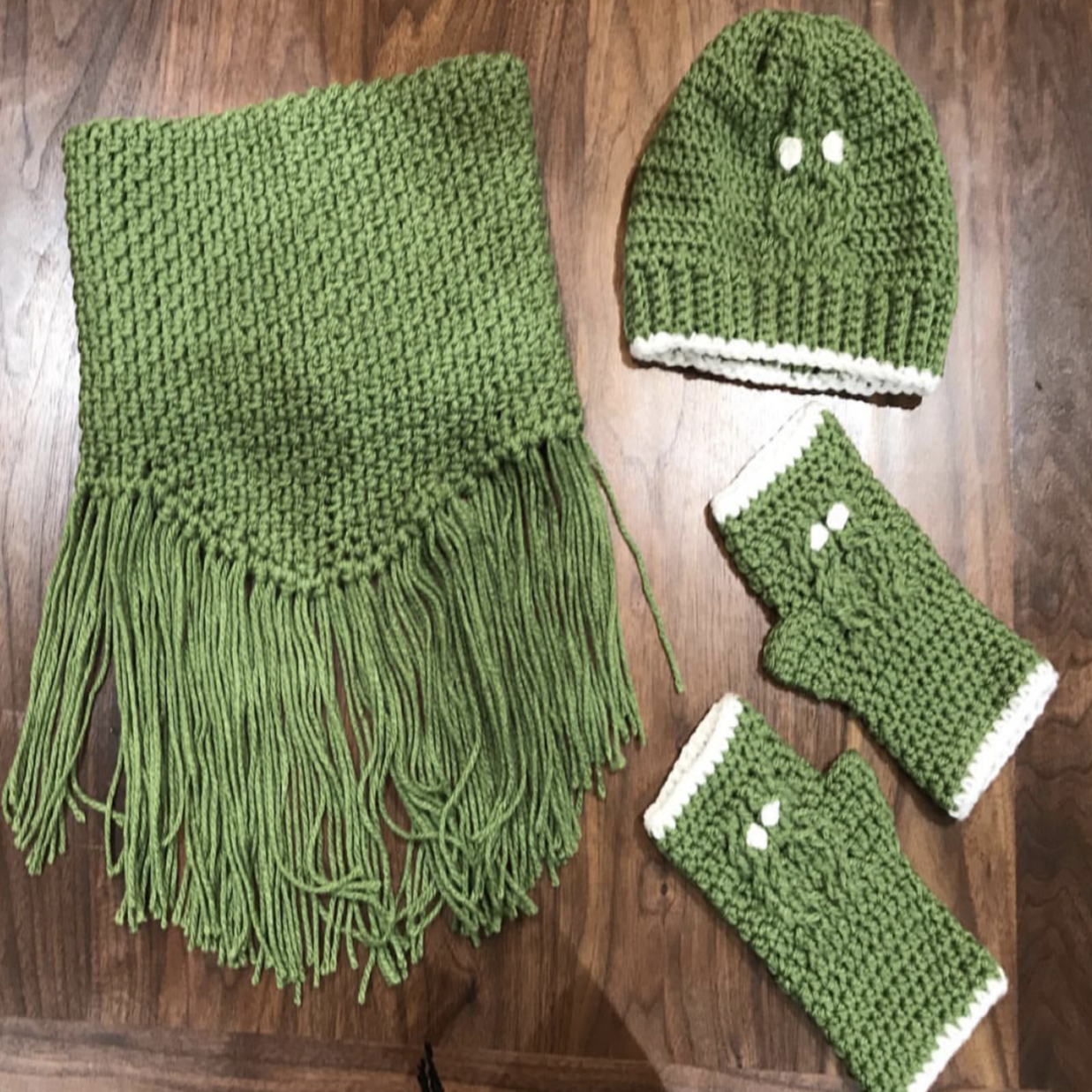 Green handmade crochet fringed cowl with matching fingerless gloves and beanie.